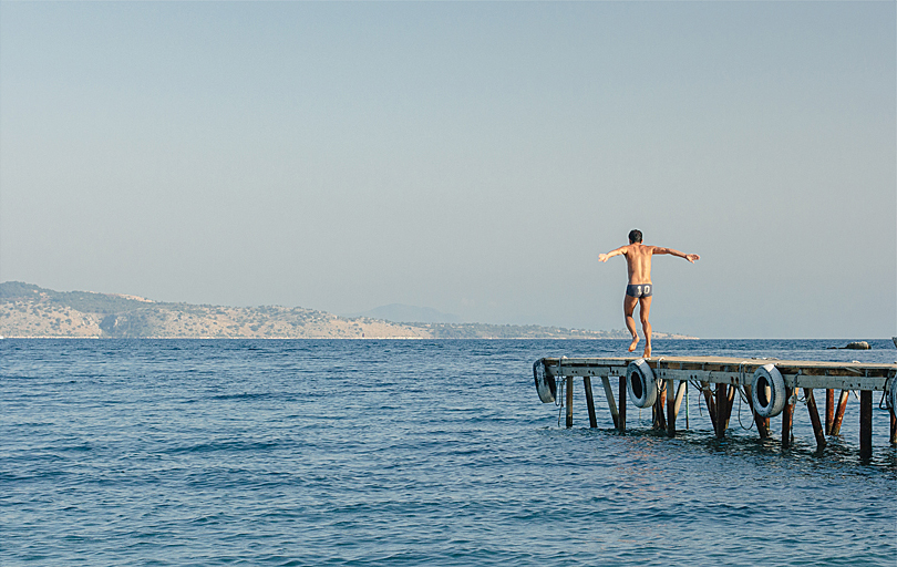 Man on the Pier at Agni Beach in Corfu Greece
